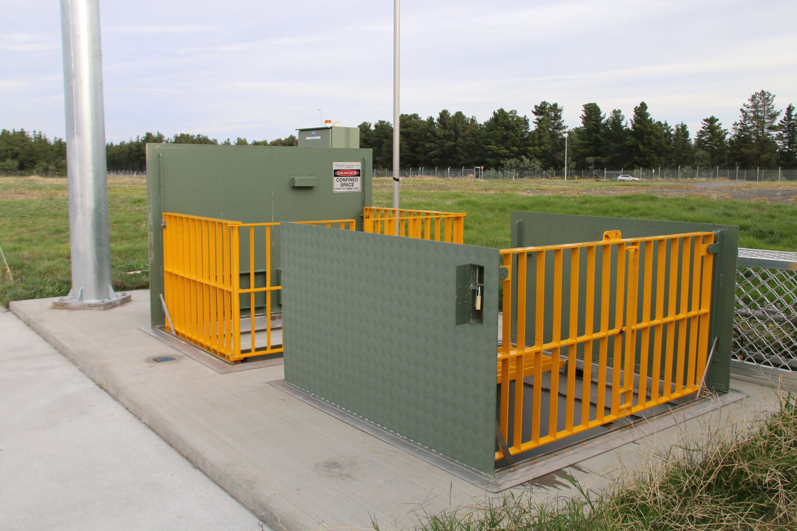 Utility enclosure with yellow safety barriers.