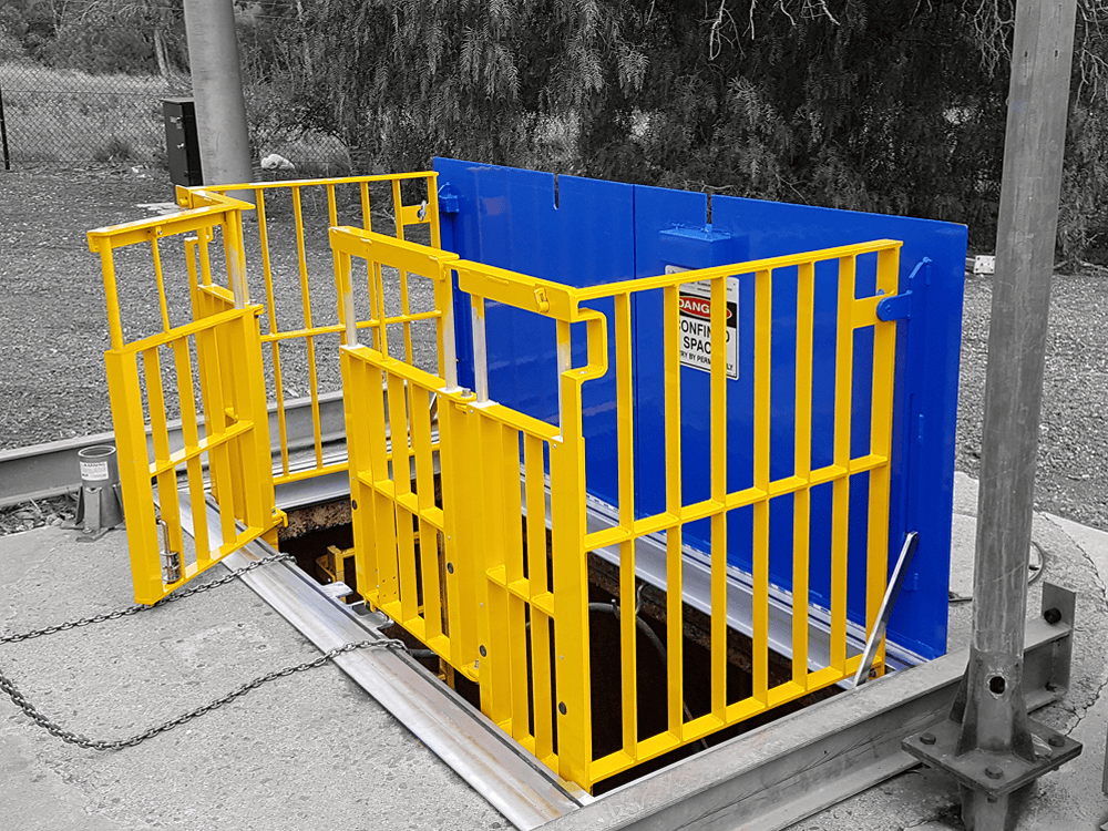 Safety barrier with open underground access hatch.