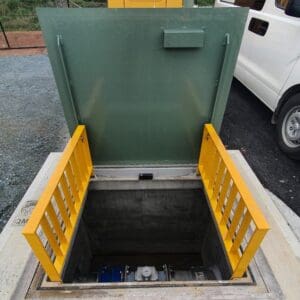 Open hatch with yellow railings and machinery.
