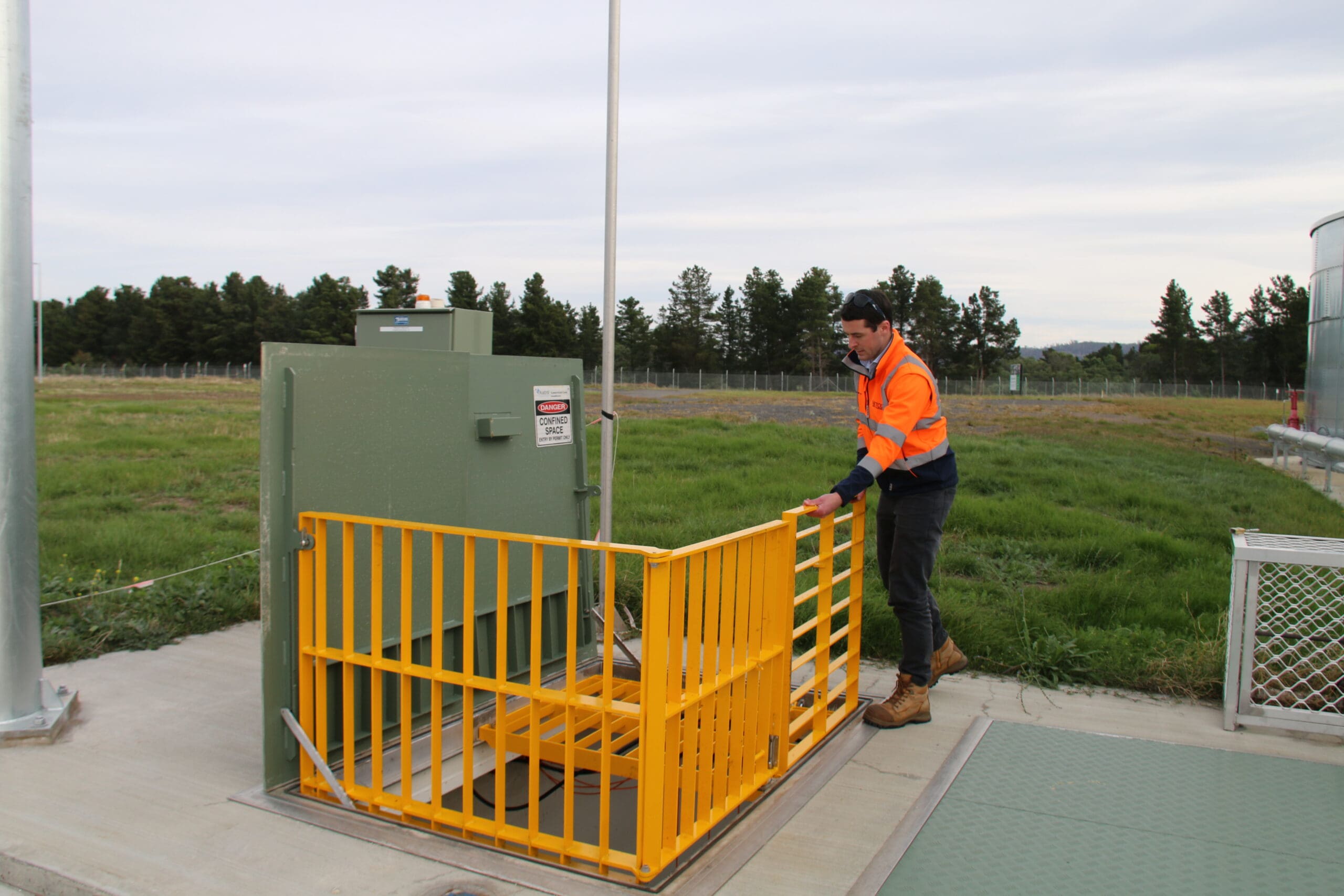 Worker operating equipment at outdoor facility.