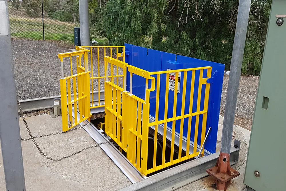 Yellow safety barriers around open underground access.