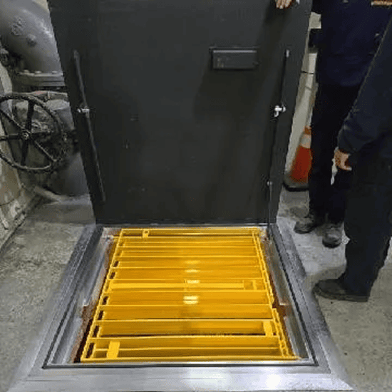 Open hatch with yellow safety barrier installed.